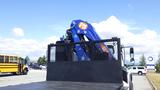 A 2017 Freightliner M2 106 truck with a blue crane mounted on its flatbed and an orange logo visible on the crane arm