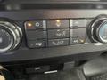 Dashboard controls of a 2016 Ford F-150 featuring climate control buttons for air conditioning and airflow direction