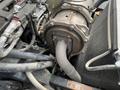 A close-up view of the engine components of a 2014 John Deere 1585 Terrain Cut showing pipes and fittings connected to the machinery