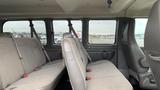 Interior view of a 2017 Chevrolet Express Quigley 4x4 showing rows of grey upholstered seats and seat belts visible