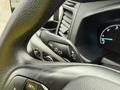 Close-up of the steering wheel controls in a 2023 Ford Transit showing buttons for lane assist and various dashboard indicators