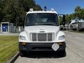 A 2004 Freightliner M2 truck with a white exterior featuring multiple lights on the roof and a rectangular license plate holder on the front bumper