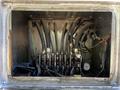 A compartment containing several hoses and pipes connected to a series of valves and gauges in a 2005 Volvo VND 122