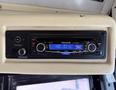 A Panasonic car stereo with an LCD display showing "NO DISC" and various buttons for sound control and settings