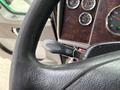 Close-up of a 2013 Kenworth T370 steering wheel showing the headlight control stalk with a silver keychain attached