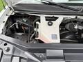 Engine compartment of a 2021 Chevrolet Express showing the coolant reservoir battery and various engine components