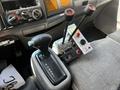 The interior console of a 2009 Ford LCF 550 featuring a gear shift lever and three control levers with labeled buttons