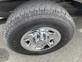 Close-up of a chrome wheel rim with a Chevrolet logo mounted on a tire with visible tread patterns labeled Bravo A/T 771