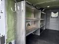 2023 Ford Transit with metal shelving unit featuring multiple shelves and hooks for storage