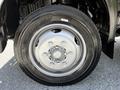 Close-up of a silver metal wheel of a 2018 Hino 195 truck featuring six bolts and a black tire with visible tread pattern