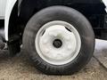 Close-up of a white wheel and tire of a 2013 Ford F-650 featuring a smooth tire surface and visible lug nuts