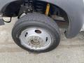 A close-up view of the wheel and tire of a 2015 Ford F-550 showing the rim and lug nuts along with a portion of the suspension system