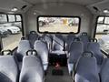 Interior of a 2018 Chevrolet Express with multiple rows of blue upholstered seats facing forward and a central seat with armrests