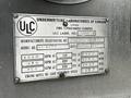 A metal plaque displaying specifications for a 1991 Sutphen Deluge fire department pumper including manufacturer registration model numbers and performance details