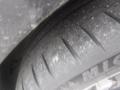 Close-up of a tire from a 2016 Porsche Boxster showing detailed tread pattern and texture on the rubber surface