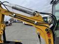 A close-up view of the arm of a 2024 AGT Industrial Yellow H13R Mini Excavator displaying hydraulic lines and a wrapped cylinder