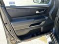 Interior door panel of a 2023 Toyota Tundra featuring a sleek design with power window controls and a textured handle