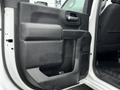 The interior door panel of a 2021 Chevrolet Silverado 3500HD featuring a textured black finish and a large storage compartment