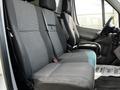 A 2012 Mercedes-Benz Sprinter featuring fabric-covered seats in shades of gray with a textured pattern and a seated position for three passengers