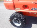 A 2008 JLG Boom Lift with a large tire and wheel prominently displayed on the right side showing its rugged tread pattern and metal rim