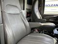 Two gray leather seats from a 2013 Chevrolet Express with armrests and adjustable controls visible in the interior cabin