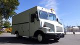 A 2004 Freightliner MT45 delivery truck with a white exterior and yellow rooftop light positioned at an angle showcasing its front and side features