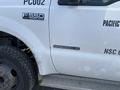 A 2002 Ford F-550 Super Duty truck with a Power Stroke Diesel V8 badge on the side and a muddy tire visible