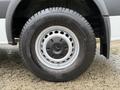 Close-up of a silver wheel and tire from a 2016 Mercedes-Benz Sprinter with visible treads and a black rubber surface