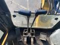 Two levers and foot pedals are visible in the foreground of a 2006 Komatsu PC55MR2 cab designed for operating the excavator's functions