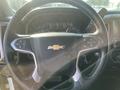 Steering wheel of a 2015 Chevrolet Silverado 1500 featuring the Chevrolet logo and controls for audio and cruise settings