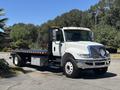 A white 2018 International DuraStar flatbed truck parked with a visible flatbed and cab featuring amber lights on the roof