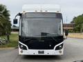 Front view of a 2018 Grande West Vicinity bus with a white and black design and illuminated headlights