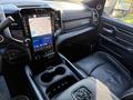 The interior of a 2023 RAM 3500 featuring a large touchscreen display in the center console black leather seats and distinctive RAM logo on the armrest