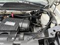 Engine compartment of a 2020 Chevrolet Express showing various components including the air intake the oil filter and the cooling system reservoir