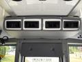 A ceiling-mounted air vent system with three adjustable vents inside a Chevrolet Express van