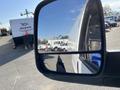 A 2014 Chevrolet Express van is reflected in the side mirror showcasing its white exterior and distinctive shape