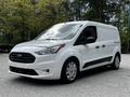 A 2019 Ford Transit Connect van in white color with a black front grille and side panels parked at an angle