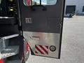 A 2006 Emergency One Fire Truck with a metal door featuring a diamond plate texture a small panel and red and white striped markings