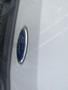 Close-up of the Ford logo on the hood of a white 2024 Ford Transit