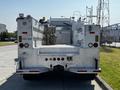 A 2004 Freightliner M2 equipped with a hose and various compartments for tools and equipment designed for utility work