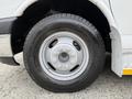 A close-up view of a silver wheel with a black tire on a 2015 Chevrolet Express van