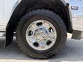 Close-up of a chrome wheel and tire from a 2020 Ram 2500 showcasing an aggressive tread pattern and shiny alloy rim