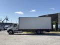 A 2015 Freightliner M2 106 box truck in profile view with a white exterior and a large cargo area attached to the chassis
