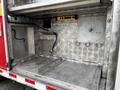 An empty storage compartment of a 2009 Spartan Gladiator featuring metallic surfaces and several mounting points