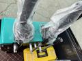 Control levers of a 2024 AGT Industrial Green QH13R Mini Excavator with protective plastic coverings and a yellow toolbox labeled tools box
