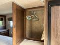 Interior closet of a 2018 Westland Travelaire with wooden paneling and hangers neatly arranged on a rod