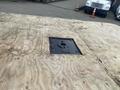 A 2017 Ford F-550 truck bed with a square cutout in the wooden floor for a mounting plate