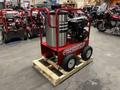 A red Magnum 4000 Hot Water Pressure Washer on a wooden pallet featuring a cylindrical water tank and a black engine with wheels for easy mobility