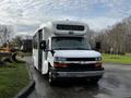 A white 2017 Chevrolet Express bus with a flat front and large windshield features large side windows and a roof vent positioned at the front