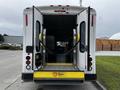 A 2016 Ford Econoline van with open rear doors showing a wheelchair-accessible ramp and interior seating visible inside